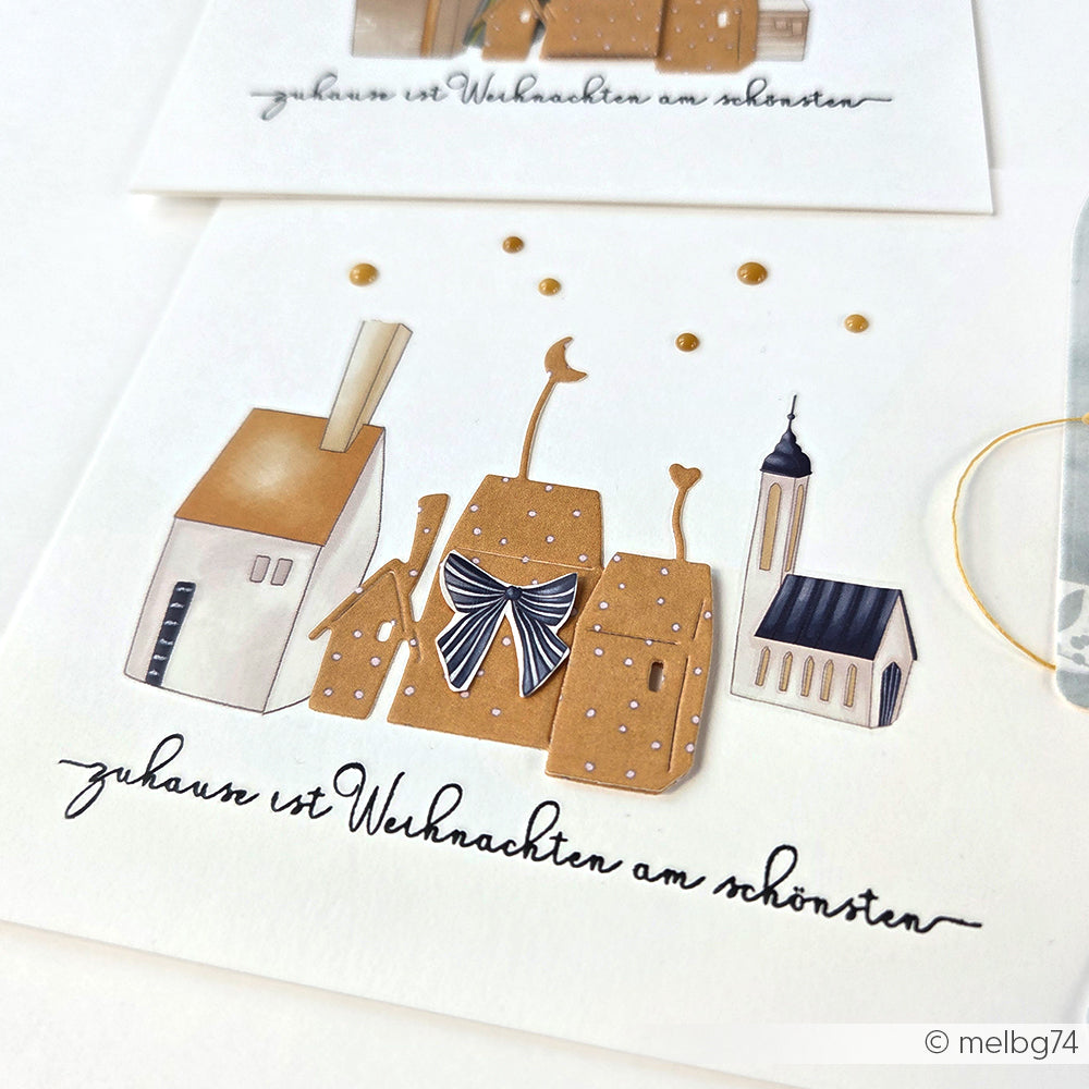 Illustration von braunen und weißen Häusern mit einer Schleife, einer Kirche und dem deutschen Text: Zuhause ist Weihnachten am schönsten. Ideal für Papierprojekte mit Alexandra Renke Clear Stamp oder Photopolymer Stempel Designs.