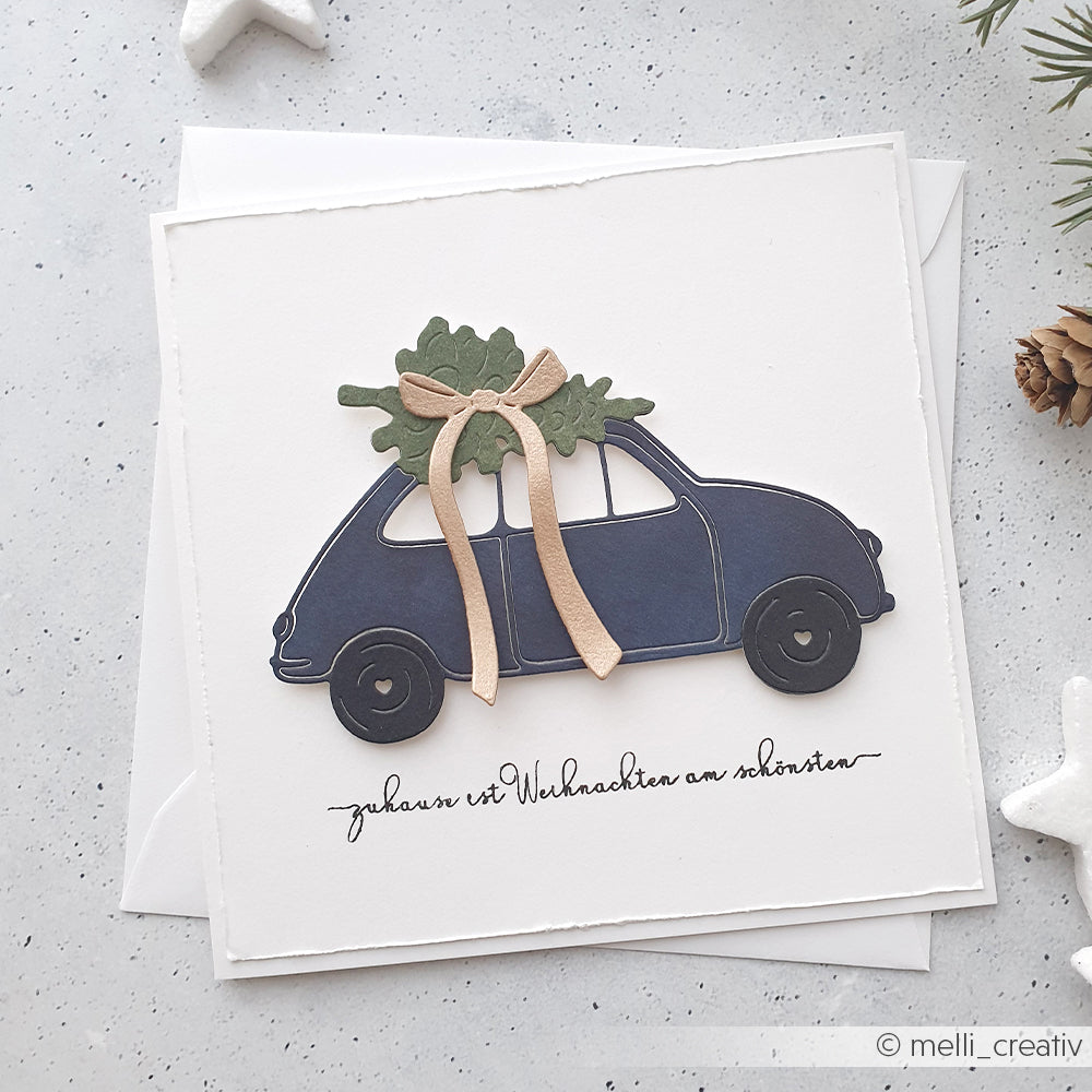 Handgefertigte Karte von Alexandra Renke mit einem blauen Auto, das einen Baum und eine Schleife trägt, akzentuiert durch Photopolymer Stempel. Spruch: "Zuhause ist Weihnachten am schönsten.