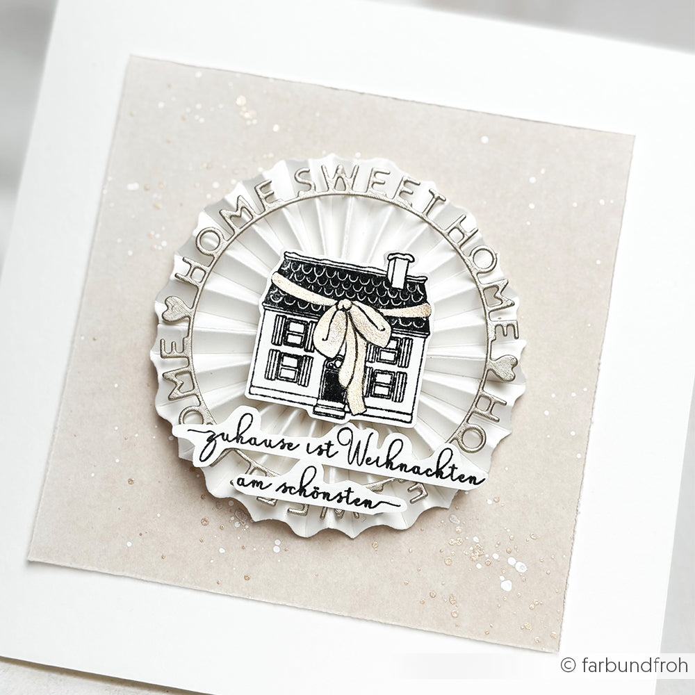 Eine dekorative Karte von Alexandra Renke zeigt ein Haus mit dem Text "Zuhause ist Weihnachten am schönsten" - ideal für Ihre Papierprojekte oder in Kombination mit einem Clear Stamp Design.