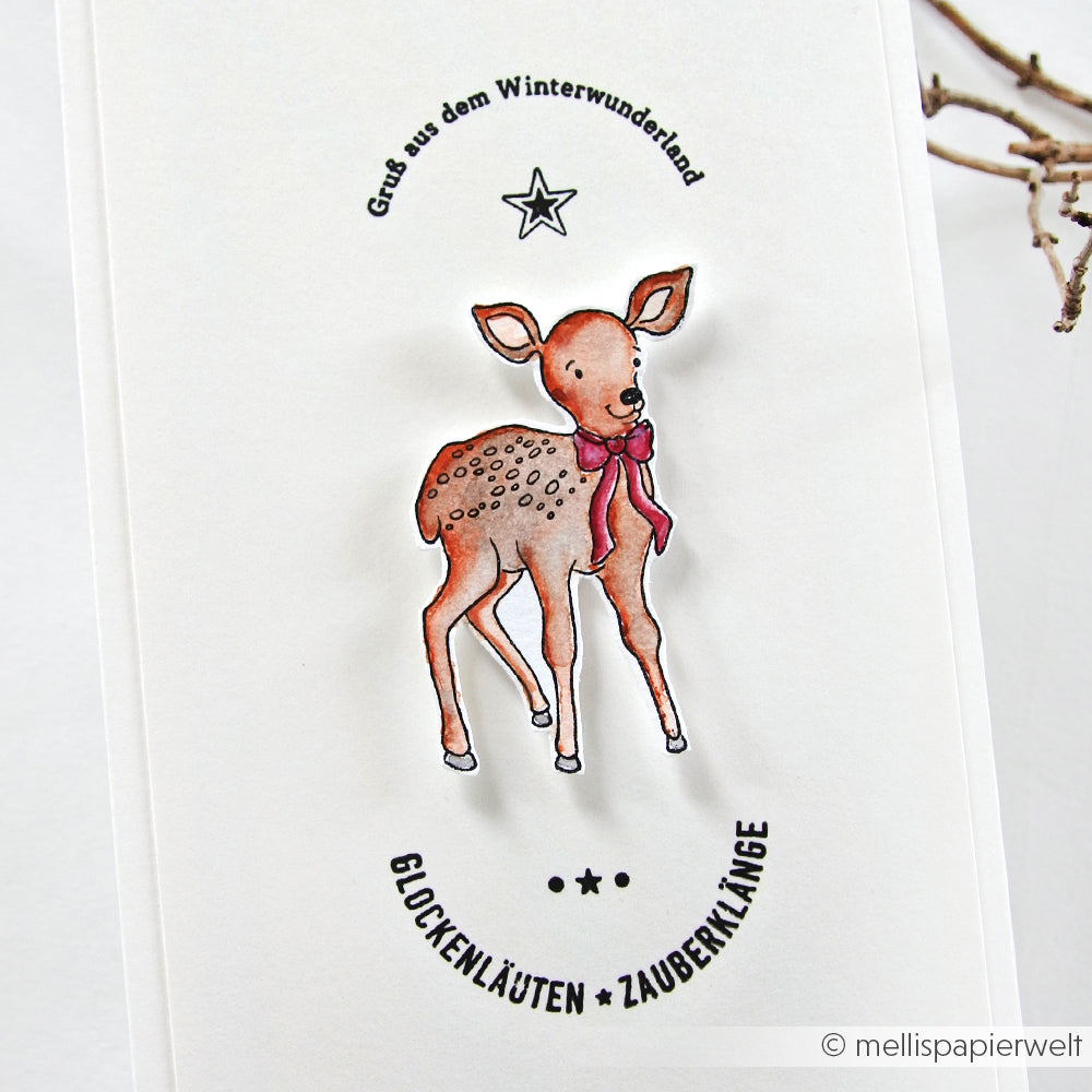 Klarsichtstempel von Alexandra Renke mit einem jungen Reh mit roter Schleife und deutschen Weihnachtsgrüßen auf einer weißen Karte - ideal für festliche Projekte und kreatives Basteln zur Weihnachtszeit.
