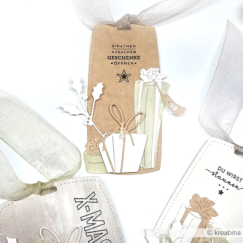 Brauner Geschenkanhänger von Alexandra Renke mit "Weihnachtszeit", illustrierten Geschenken, Stechpalmen und weißem Band. Hergestellt mit einem Photopolymer-Klarsichtstempel für gestochen scharfe, festliche Details.