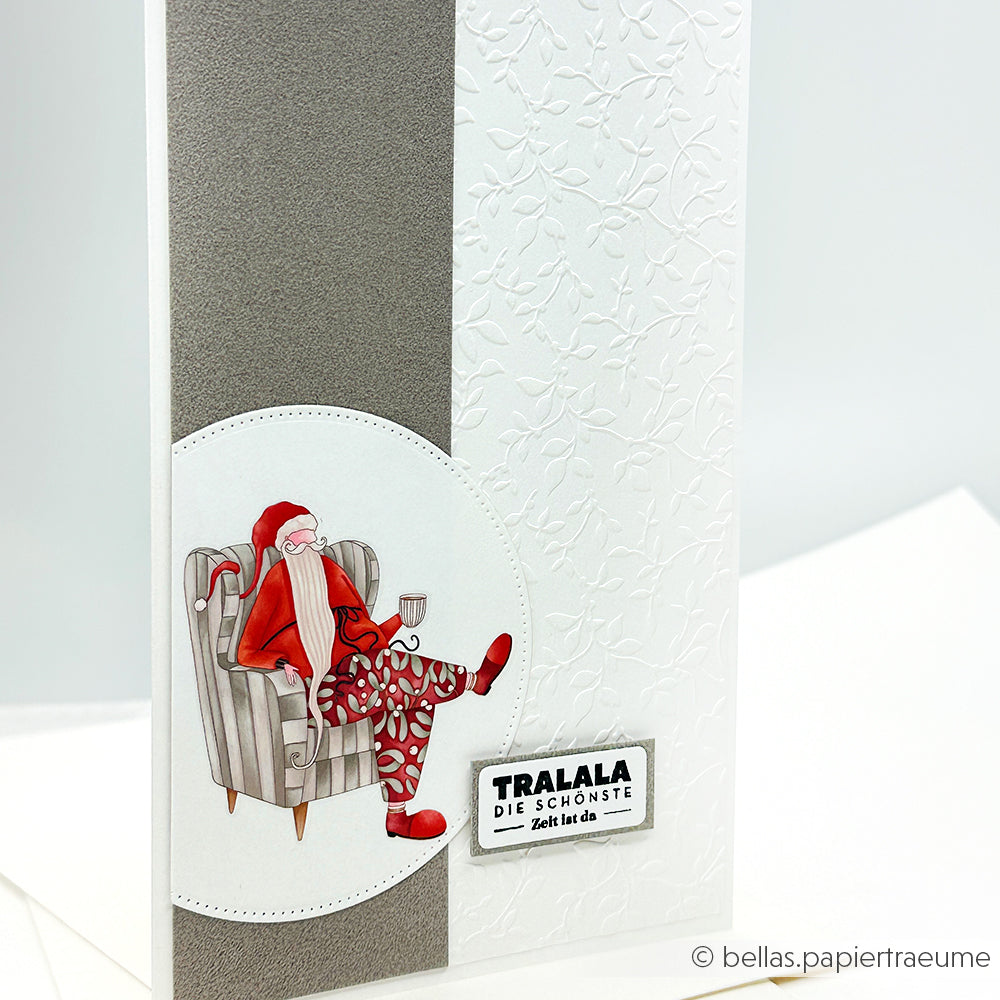 Eine weihnachtliche Karte von Alexandra Renke mit einem Weihnachtsmann im Sessel und "Tralala Die schönste Zeit ist da", perfekt zum Teilen von Adventszauber.