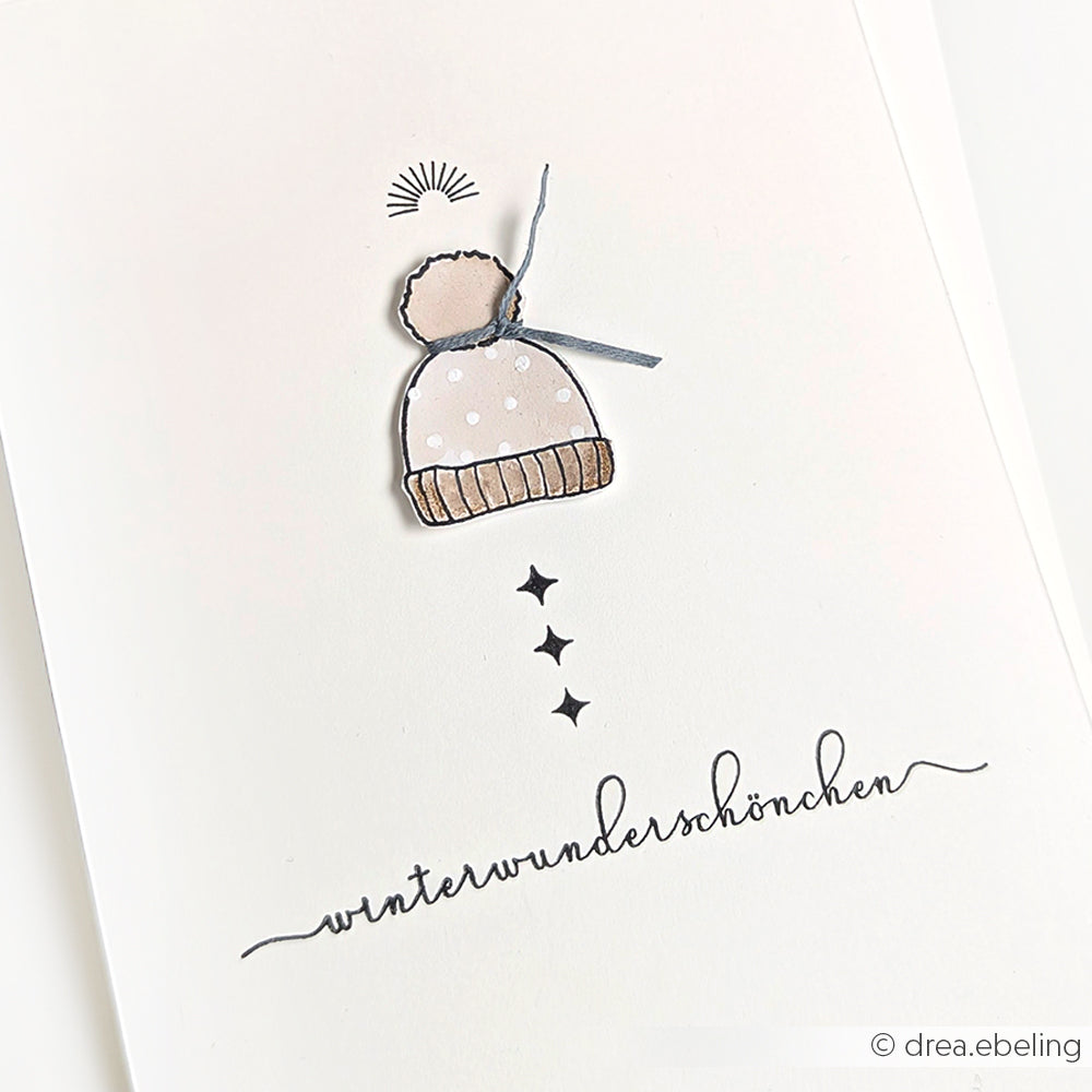 Eine schlichte Zeichnung einer beigen Wintermütze über dem handgeschriebenen "Winterwunderschönchen" von Alexandra Renke, perfekt zum Festhalten von Eiskristallträumen oder als klarer Stempel in Ihren kreativen Projekten.