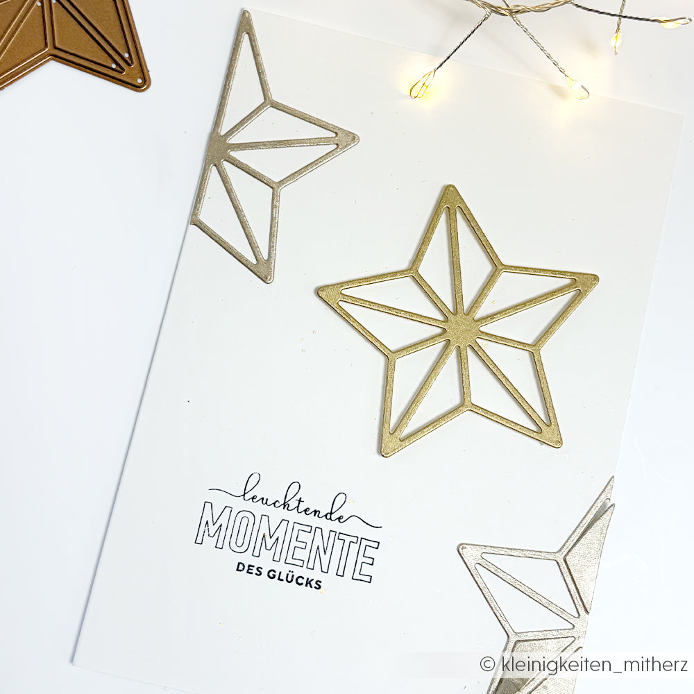 Weiße Karte mit geometrischen Sternen in Gold und Silber, hergestellt mit dem Clear Stamp Eiskristallträume von Alexandra Renke. Mit deutschem Text: "leuchtende MOMENTE DES GLÜCKS.