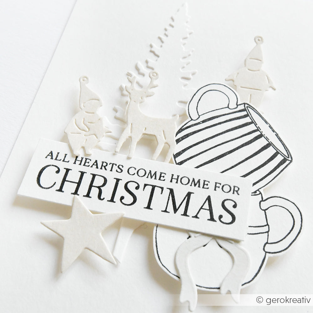 Handgefertigte Weihnachtskarte von Alexandra Renke mit ausgeschnittenen Figuren, Tassen, einem Stern und dem Text "Alle Herzen kommen zu Weihnachten nach Hause", hergestellt mit Clear Stamp und Stempelkissen für knackige, festliche Details.