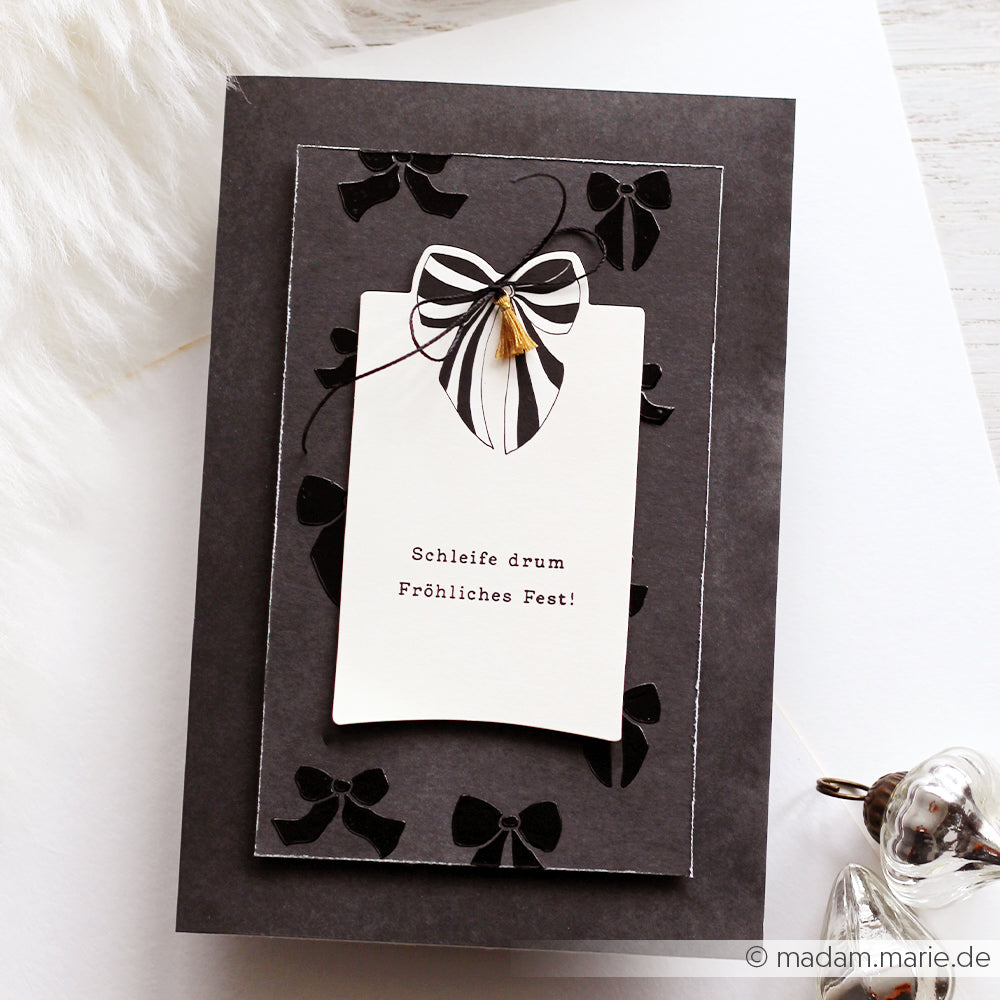 Eine schwarz-weiße Festtagskarte von Alexandra Renke mit Schleifenmotiven und dem Text "Schleife drum Fröhliches Fest!", perfekt zum Basteln mit Clear Stamp oder Photopolymer und zum Teilen von Weihnachtsfreude.