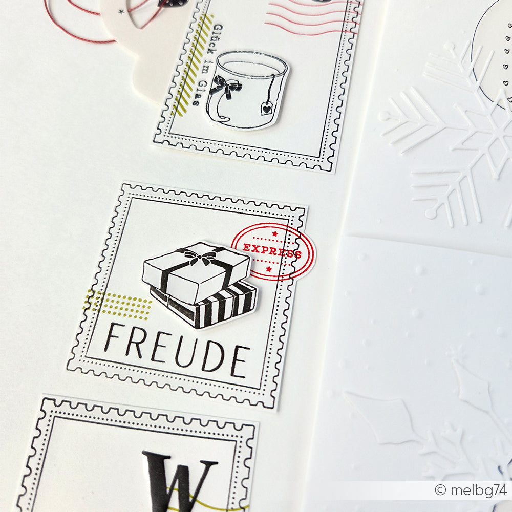 Eine Nahaufnahme der Clear Stamps von Alexandra Renke mit einer Tasse und einem "FREUDE"-Geschenk mit geprägten Schneeflocken, ideal für festliche Weihnachtsstempel-Designs.