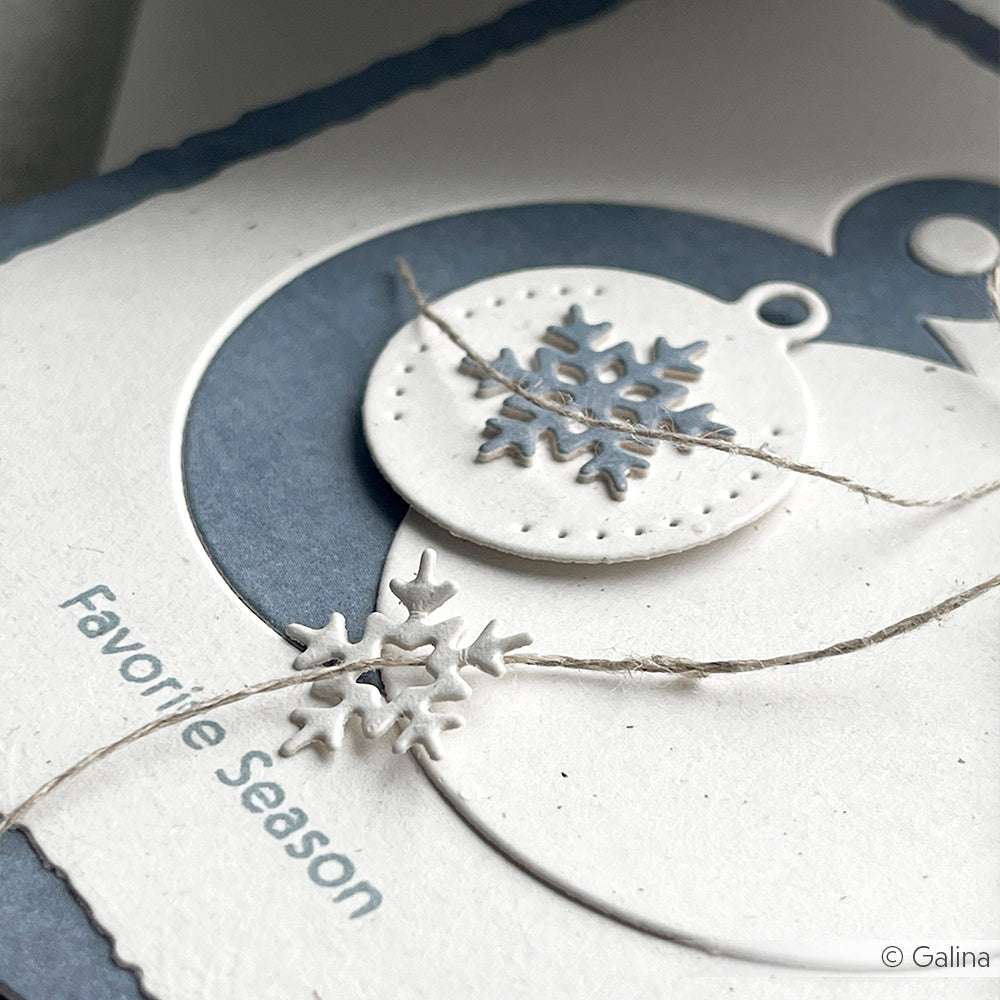 Nahaufnahme einer handgefertigten Weihnachtskarte mit einer Schneeflocke, die mit dem Alexandra Renke Motivstanze Schneeflocken Dies Set, Bindfaden und dem Spruch "Lieblingsjahreszeit" erstellt wurde.