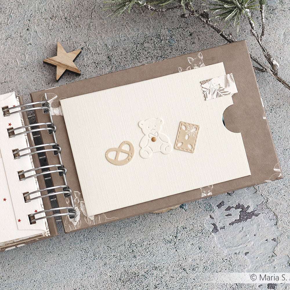 Gestalten Sie ein Scrapbook mit einer Karte, die einen Bären, eine Brezel und ein Buch auf einem strukturierten Hintergrund zeigt - ideal für die Verwendung von Alexandra Renke Stanzen für Papierbasteln oder Ihren bevorzugten Motivstanze Winter-Leckereien DieCut Systemen.