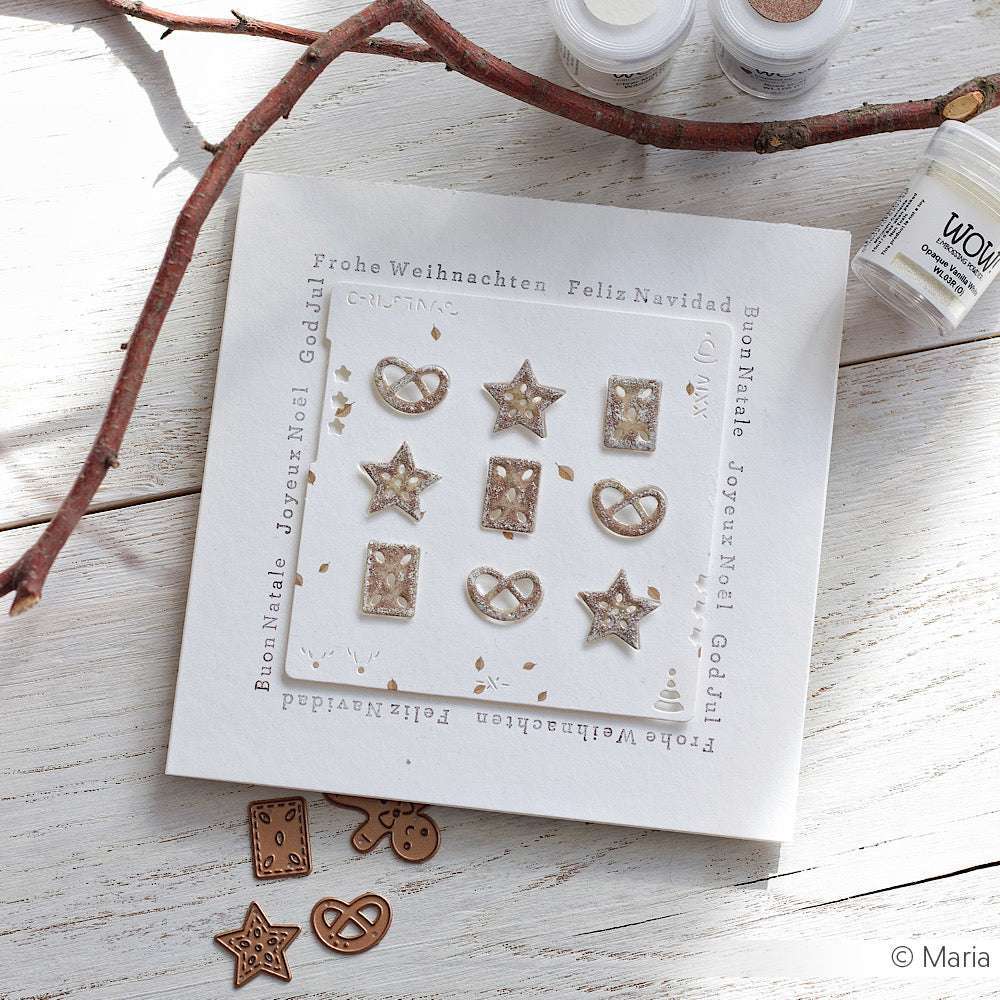 Quadratische Weihnachtskarte von Alexandra Renke mit Metallic-Sternen und Brezeln, hergestellt mit DieCut Systemen und Motivstanze Winter-Leckereien, umgeben von mehrsprachigen Grüßen.