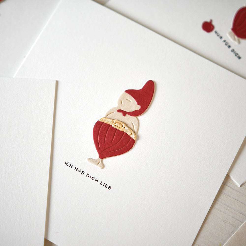 Eine Karte von Alexandra Renke mit einem rot-beigen Wichtel aus der Motivstanze Wichtel Tomte und dem deutschen Text "ICH HAB DICH LIEB" darunter.