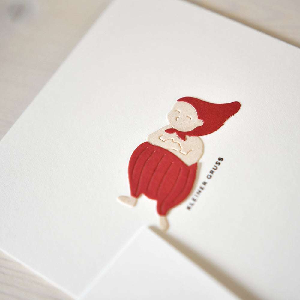 Eine schlichte Karte mit einer lächelnden Figur in roter Kleidung und Hut, hergestellt mit der Alexandra Renke Motivstanze Wichtel Sven Stanzen, und dem Text KLEINER GRUSS.