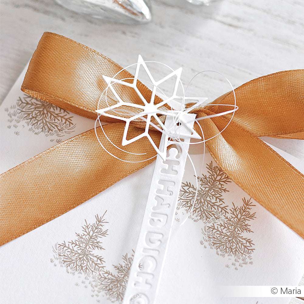 Geschenk mit goldener Schleife und weißem Stern-Ornament, gefertigt mit der Motivstanze Stern von Alexandra Renke, sowie einem zarten Baummotiv auf hochwertigem Designpapier.