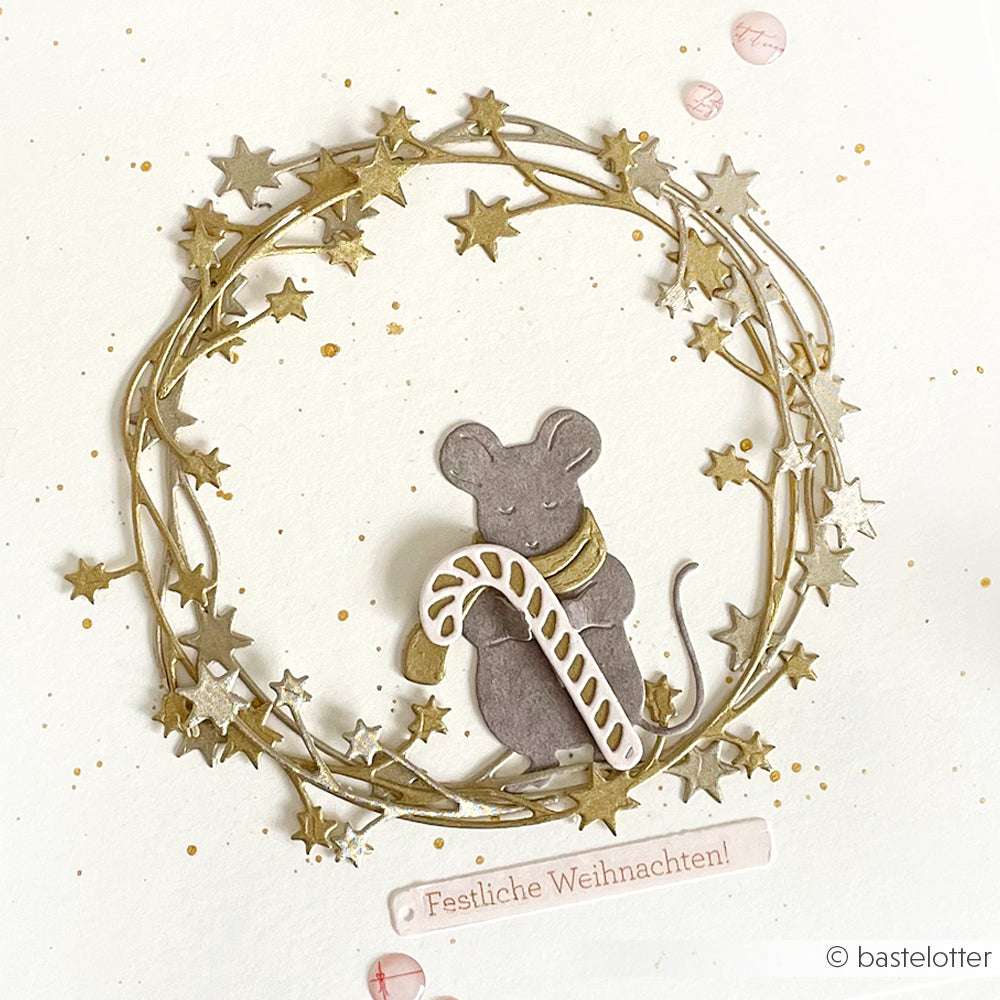 Eine niedliche Maus, die mit den Motivstanze Tier Duo Mäuserich & Otter von Alexandra Renke ausgestanzt wurde, hält eine Zuckerstange in einem goldenen Sternenkranz mit "Festliche Weihnachten!" darunter.