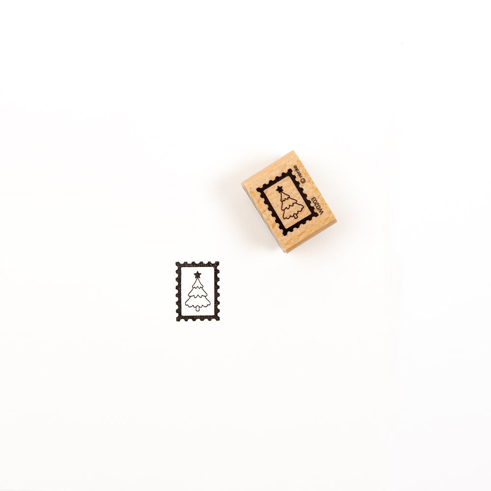 Ein Weihnachtsbaum-Stempel aus Holz neben seinem Abdruck auf weißem Papier – ideal für verschiedene Papierprojekte.