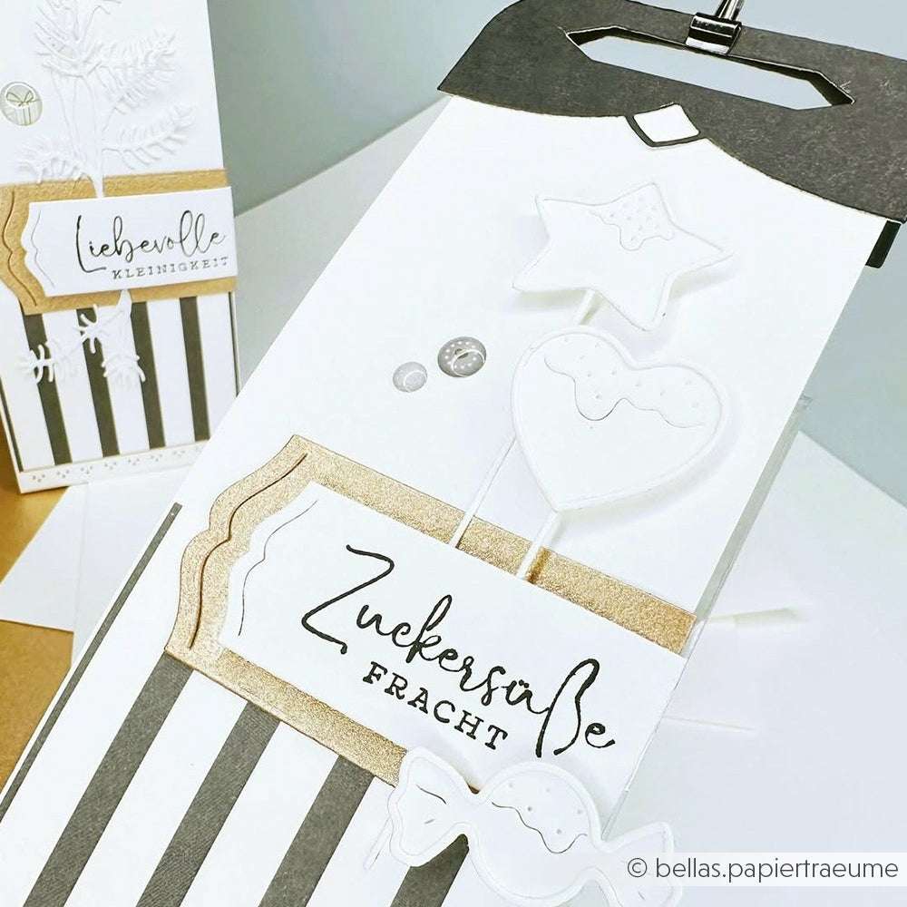 Die Geschenkverpackung von Alexandra Renke ist schwarz-weiß gestreift, mit goldenen Akzenten und dem Schriftzug "Zuckersüße Fracht" versehen - perfekt, um sie mit Designpapieren oder Ihren bevorzugten DieCut Systemen zu kombinieren.