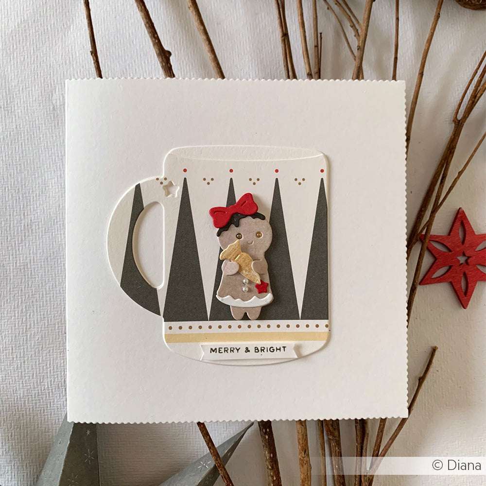 Handgefertigte Weihnachtskarte mit einer Tasse, grauen Bäumen und einem Lebkuchenmädchen, das eine Zuckerstange mit roter Schleife hält. Die Motivstanze Lebkuchen-Kinder Bäckerei von Alexandra Renke sorgt für zusätzlichen festlichen Charme.