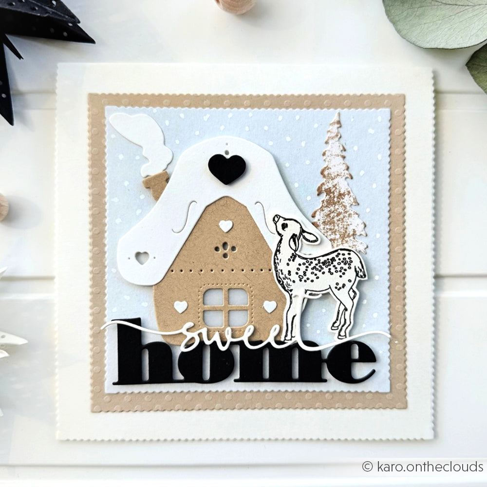 Handgefertigte Karte von Alexandra Renke mit einem Häuschen, einem Reh, einem Baum, Schnee und "Sweet Home" in fetten schwarzen und weißen Buchstaben, hergestellt mit DieCut Systemen und hochwertigen Designpapieren für zusätzliche Details.