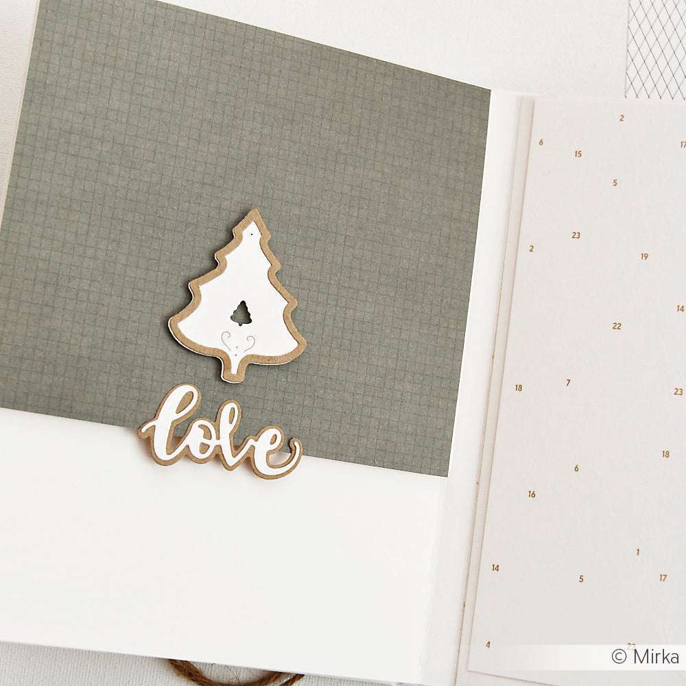 Eine handgefertigte Weihnachtskarte von Alexandra Renke aus Designpapier mit einem ausgeschnittenen Baum und dem Text "Liebe" auf grauem Hintergrund.