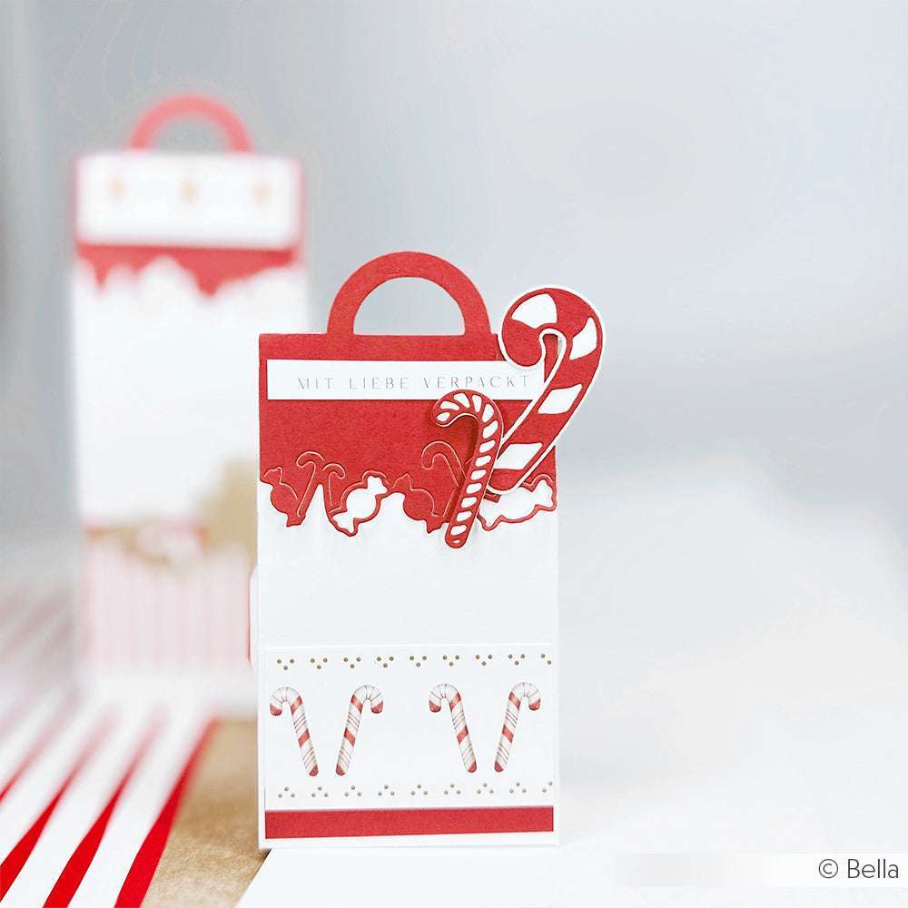 Rot-weiße Alexandra Renke Geschenktüte mit Zuckerstangen-Dekor, gebördeltem Rand und dem Etikett "Mit Liebe verpackt", hergestellt mit der Motivstanze Tütengriff Süßigkeiten für eine charmante Note.