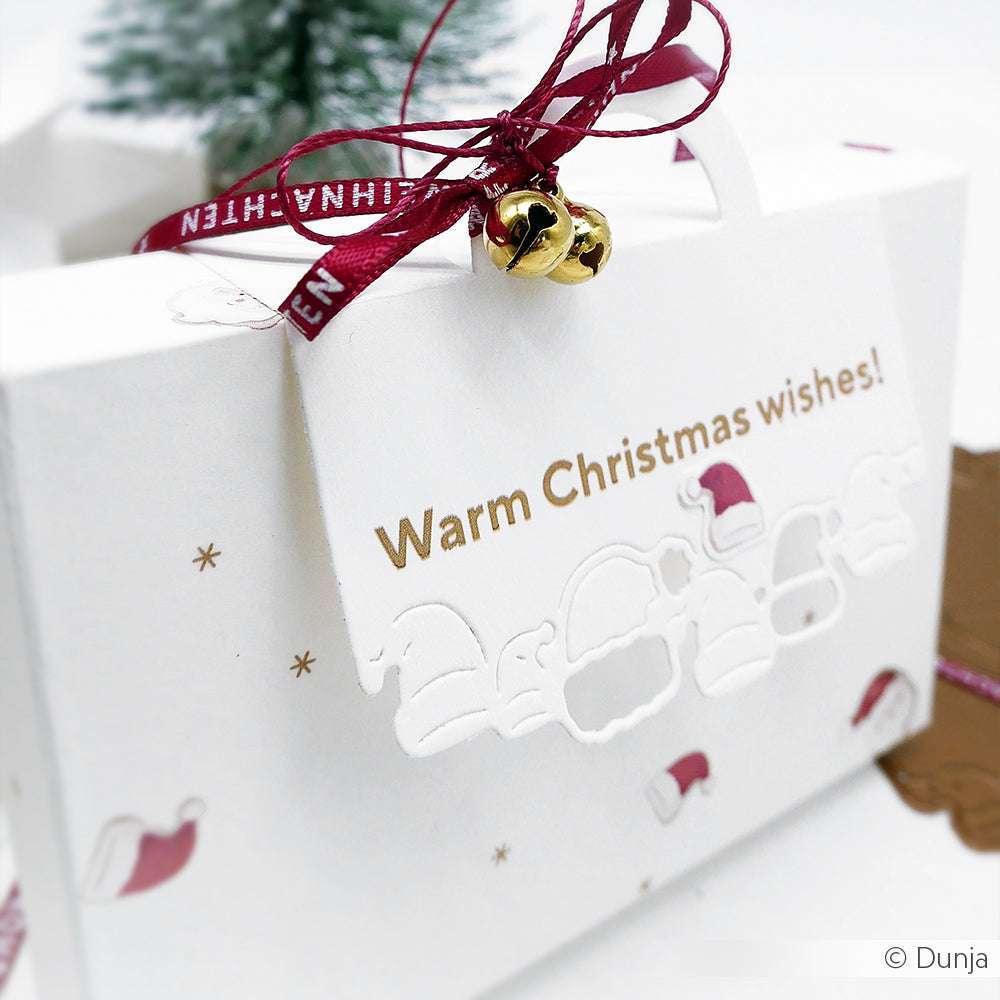 Weiße Geschenkschachtel von Alexandra Renke mit "Herzliche Weihnachtswünsche!"-Anhänger, rotem Band, goldenen Glöckchen und festlichen Designpapieren plus DieCut Systeme-Akzenten für eine ganz besondere Weihnachtsnote.