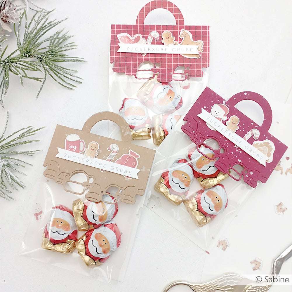 Drei festliche Geschenktüten von Alexandra Renke, gefüllt mit Weihnachtspralinen, verziert mit weihnachtlichen Designpapieren und beschriftet mit "Zuckersüße Grüße".