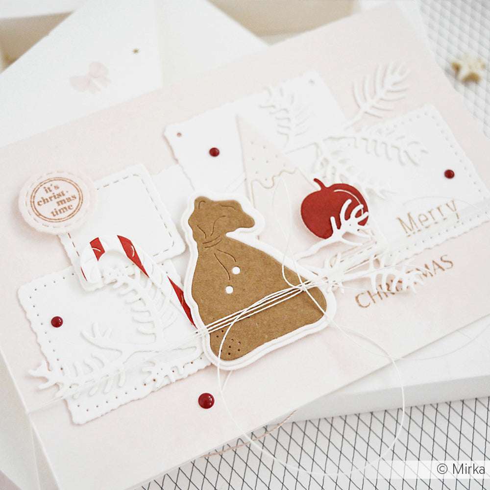 Handgefertigte Weihnachtskarte von Alexandra Renke, gestaltet mit Designpapier und Ausschnitten, mit einer Zuckerstange, einem roten Ornament und dem festlichen Text "Frohe Weihnachten".