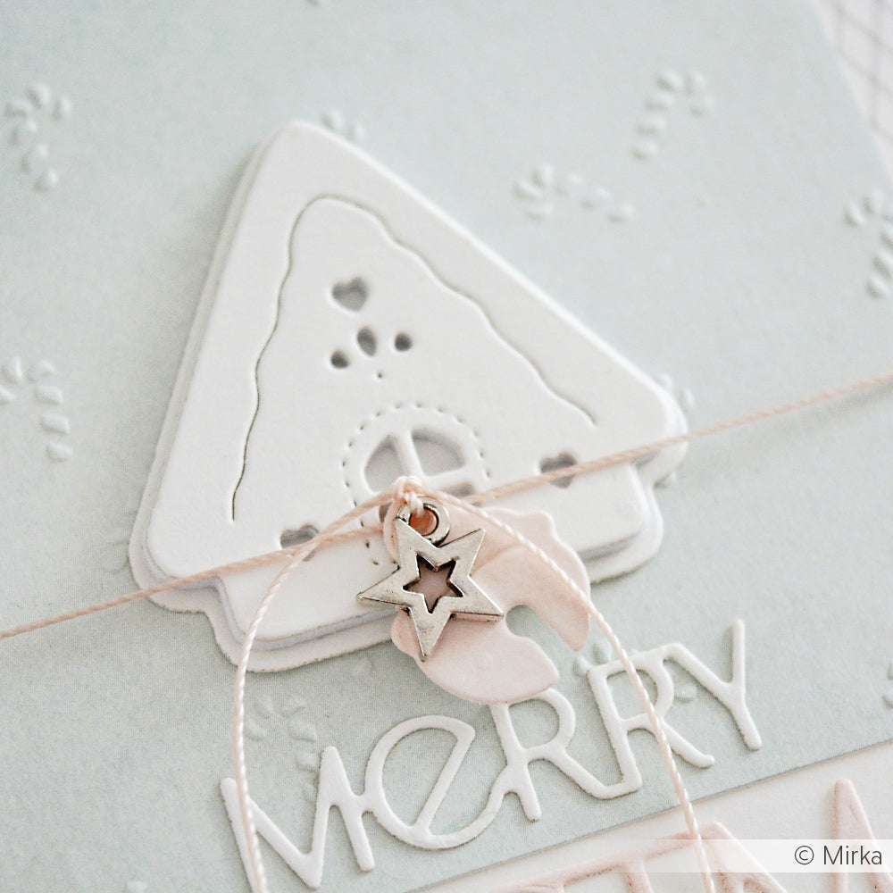 Nahaufnahme einer weißen Weihnachtskarte, die mit dem Designpapier von Alexandra Renke gestaltet wurde, mit einem Haus, einem Stern und dem Wort "MERRY", das am unteren Rand geprägt ist.