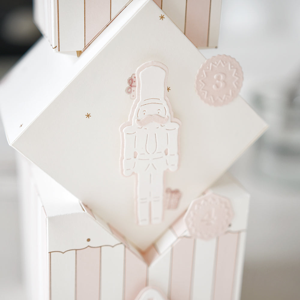 Eine weiße Schachtel von Alexandra Renke mit einer rosa geprägten Motivstanze Nussknacker und der Zahl 3 im Kreis oben rechts, ideal zum Präsentieren von Designpapieren oder zur Verwendung mit DieCut Systemen.