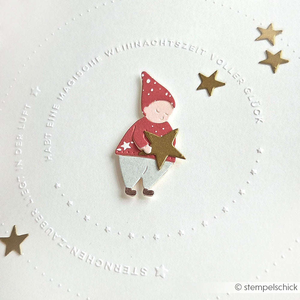 Alexandra Renke Design mit einem roten Wichtel, der einen Stern hält, umgeben von goldenen Sternen und geprägtem deutschem Text - ideal für Wichtel Sternwanderung oder Bastelprojekte mit Ihrer Lieblingsmotivstanze.