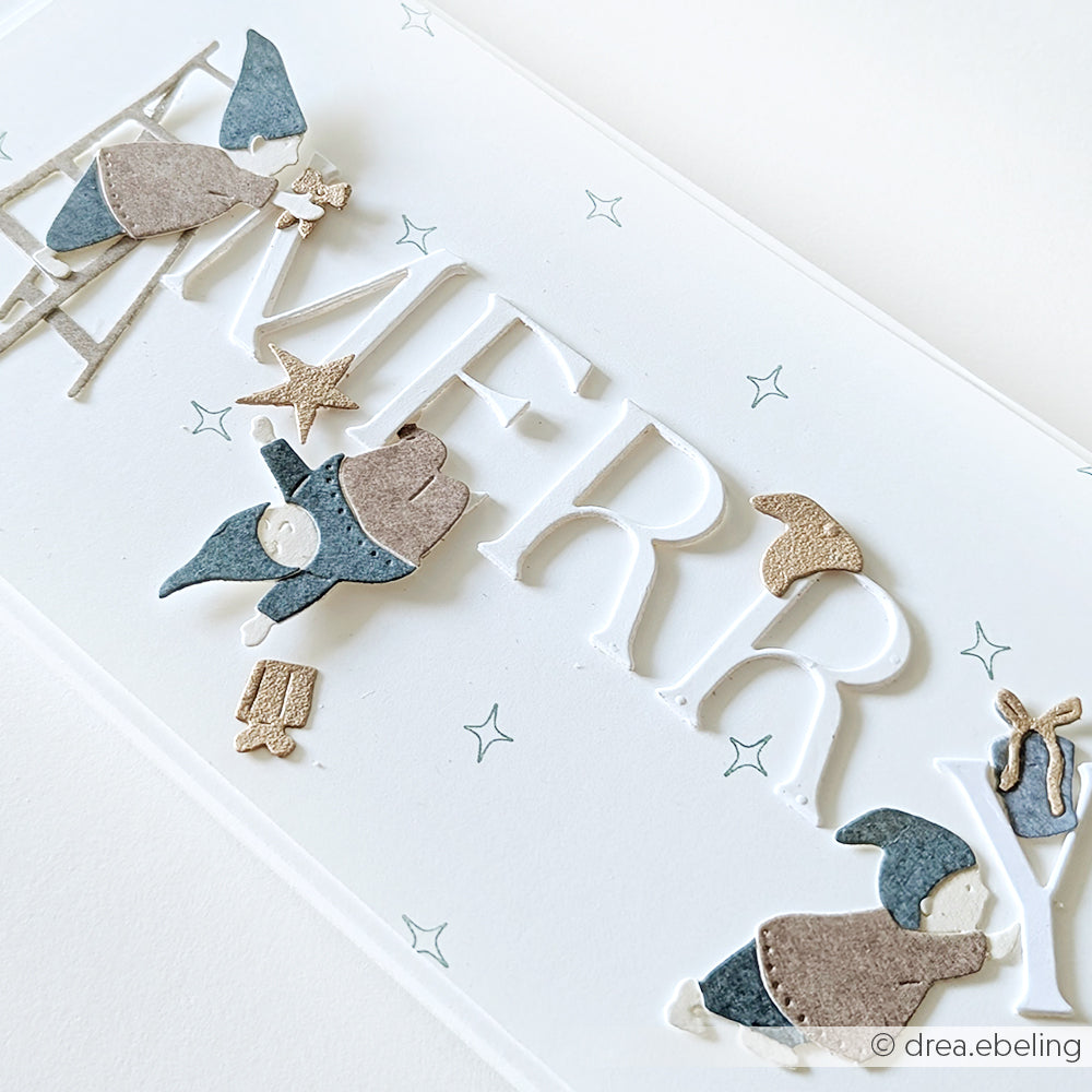 Handgemachte Karte von Alexandra Renke mit ausgeschnittenen MERRY-Buchstaben, kleinen Wichteln aus Motivstanze Wichtel, Sternen, Geschenken und einem Pilzdekor auf hochwertigem Designpapier.