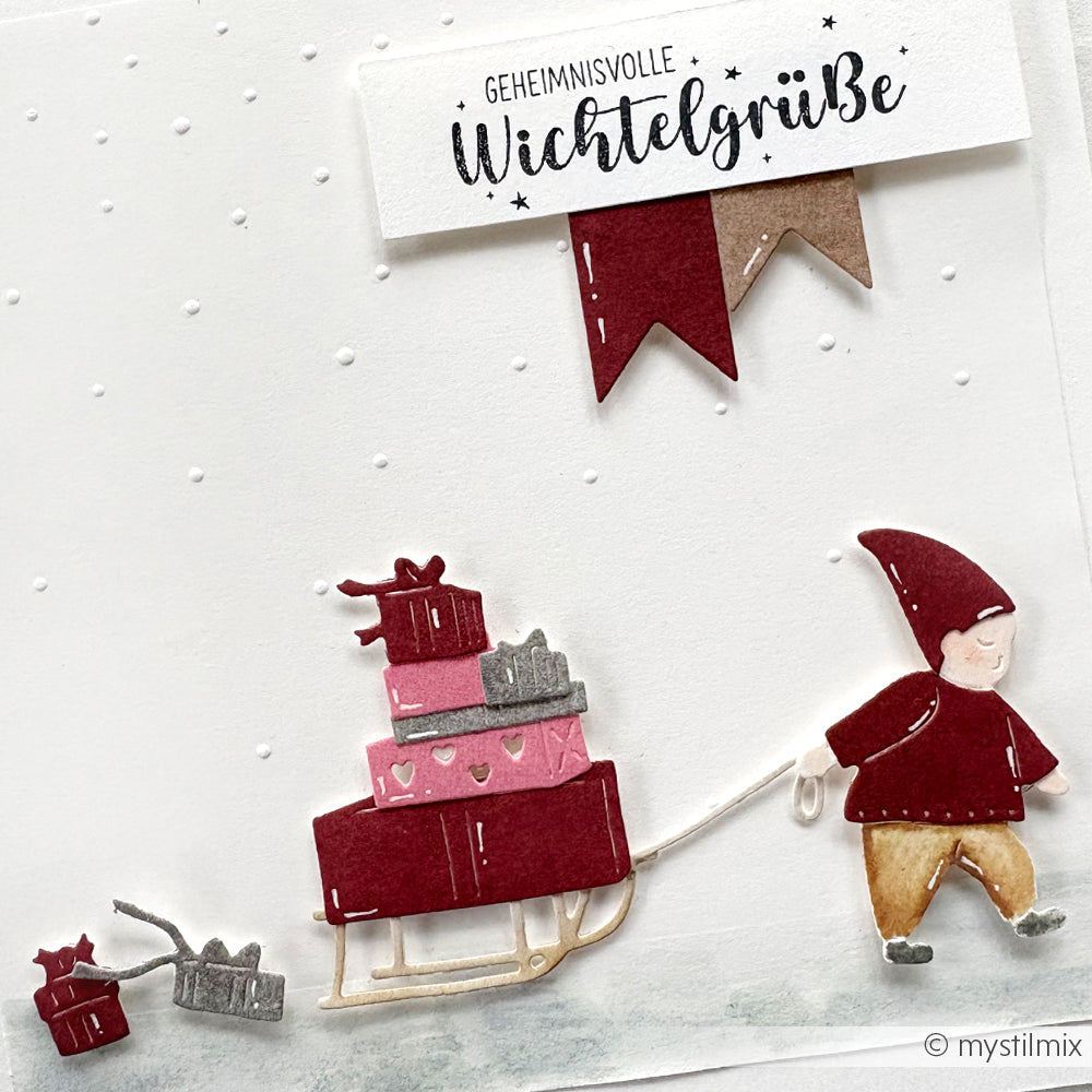 Eine Illustration von Alexandra Renke, die einen Zwerg zeigt, der einen Schlitten mit Geschenken und einem kleinen Schlitten zieht, mit deutschem Text darüber - ideal für Geschenke-Lieferdienst-Projekte oder als Inspiration für winterliche Motivstanze.