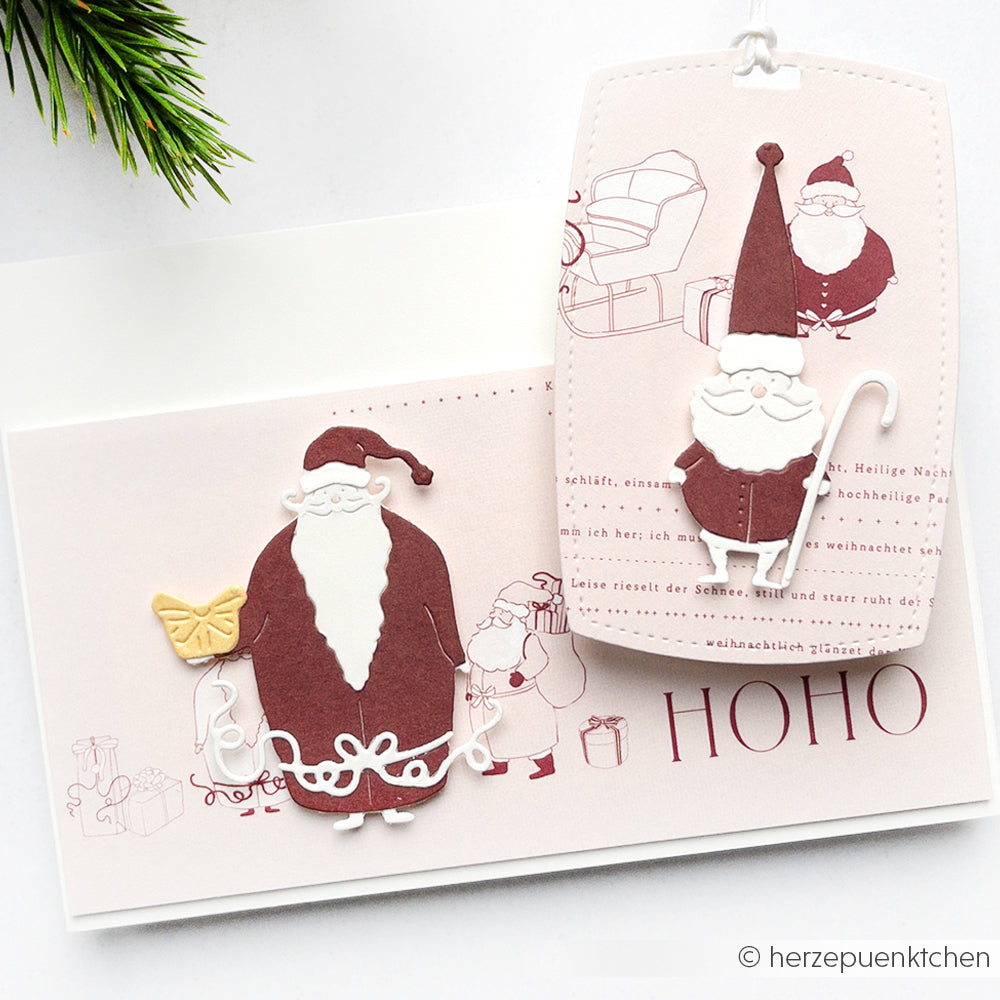 Handgefertigte Weihnachtskarte und Anhänger mit Weihnachtsmannmotiven aus Papier auf weißem und rosa Hintergrund, hergestellt mit Alexandra Renke Motivstanze Weihnachtsmann-Duo und festlichem Designpapier.