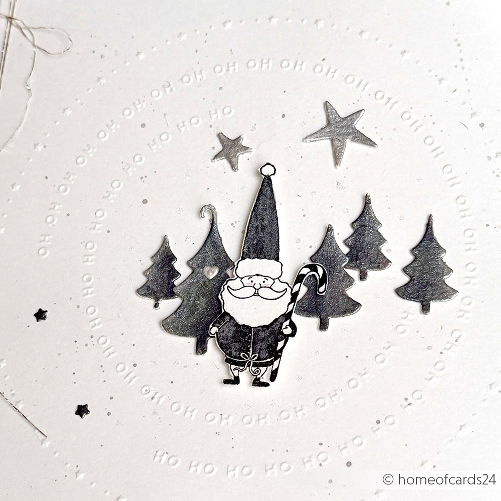 Schwarz-weiße Weihnachtsmann-Zeichnung mit Bäumen, Sternen und "HO HO HO" in einem kreisförmigen Muster auf Weiß - perfekt für Designpapiere oder zur Verwendung mit der Motivstanze Weihnachtsmann-Duo Stanzsysteme von Alexandra Renke.