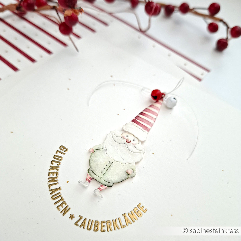 Eine festliche Weihnachtsmannkarte von Alexandra Renke mit "Glöckchenläuten * Zauberklänge", roten Beeren im Hintergrund, gestaltet mit der Motivstanze Weihnachtsmann-Duo.