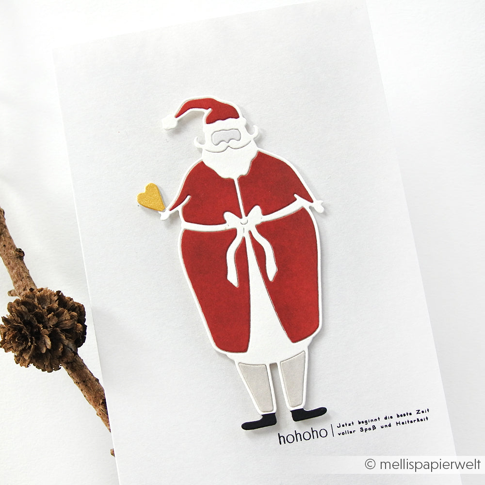 Minimalistische Weihnachtsmann-Illustration mit goldenem Herz, erstellt mit der Motivstanze Weihnachtsmann mit Herz von Alexandra Renke, mit "hohoho" und einem deutschen Weihnachtsgruß. Ideal für DieCut Systeme und festliche Designpapiere.