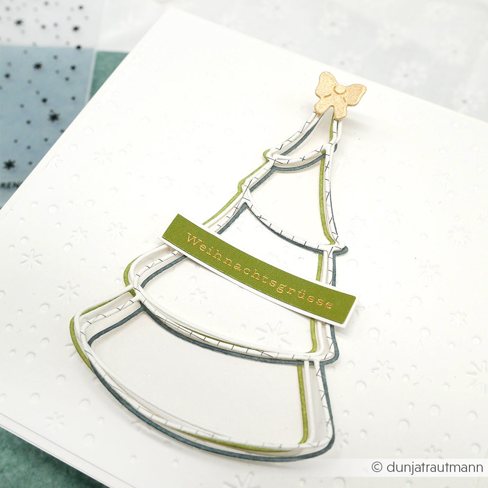 Minimalistische Weihnachtskarte von Alexandra Renke mit einem stilisierten Outline-Tannenbaum mit Schleife und goldenen Weihnachtsgrüßen auf einem grünen Banner; ideal zum Basteln mit Stanzen für DieCut Systeme.