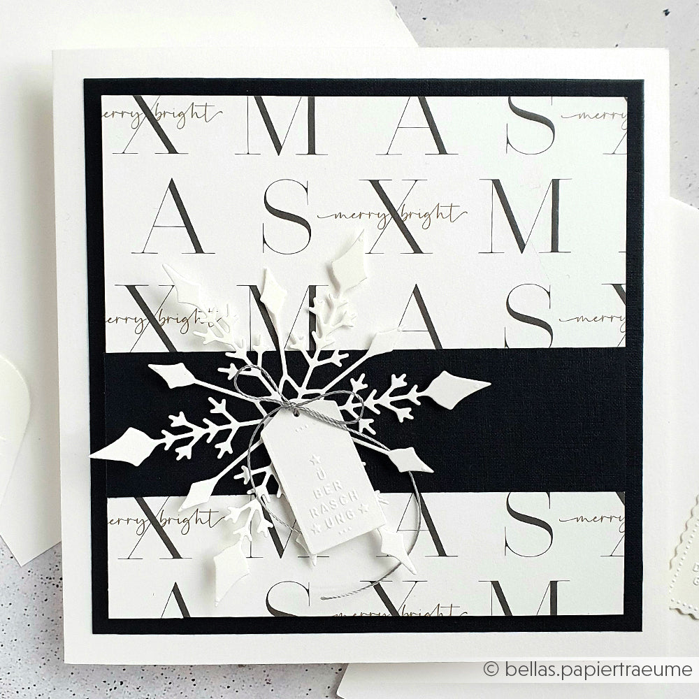 Elegante Weihnachtskarte von Alexandra Renke mit den Texten XMAS und merry & bright, einem schwarzen Band, einer Schneeflocke aus der Motivstanze Große Schneeflocke und einem weißen Geschenkanhänger. Ideal für Fans von Stanzen für Designpapier oder DieCut Systeme.