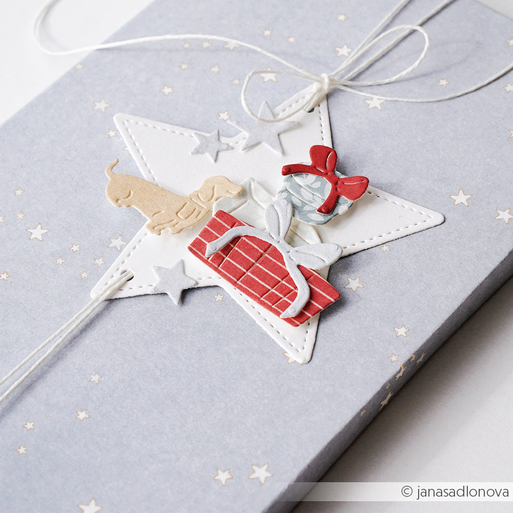 Geschenkbox mit einem sternförmigen Anhänger, auf dem ein Dackel und ein Geschenk abgebildet sind, gestaltet mit der Motivstanze Schneeflockenstern.