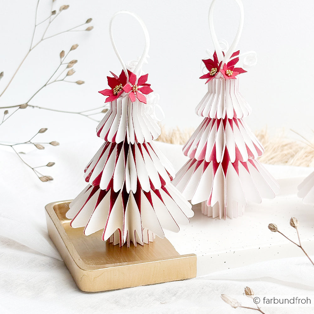Zwei Weihnachtsbaumschmuckstücke aus Papier, verziert mit winterlichem Blumenkonfetti und Weihnachtssternen.