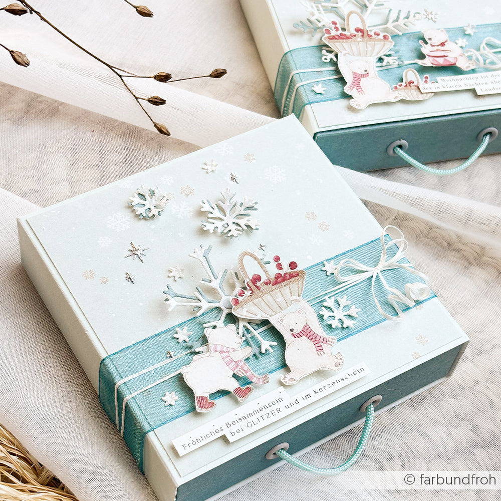 Zwei hellblaue Geschenkboxen, verziert mit winterlichen Designpapieren und ausgeschnittenen Eisbärenmotiven.