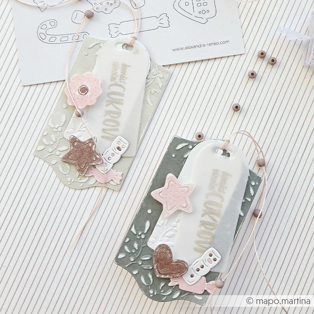 Zwei verzierte Geschenkanhänger mit der Aufschrift domácí cukroví und Motiven im Stil von Weihnachtskonfekt.