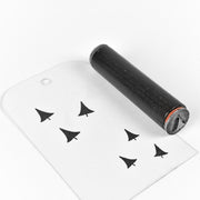 Ein schwarzer Stempel von Alexandra Renke und gestempelte Bilder von kleinen Bäumen auf einem weißen Anhänger mit einem Loch.