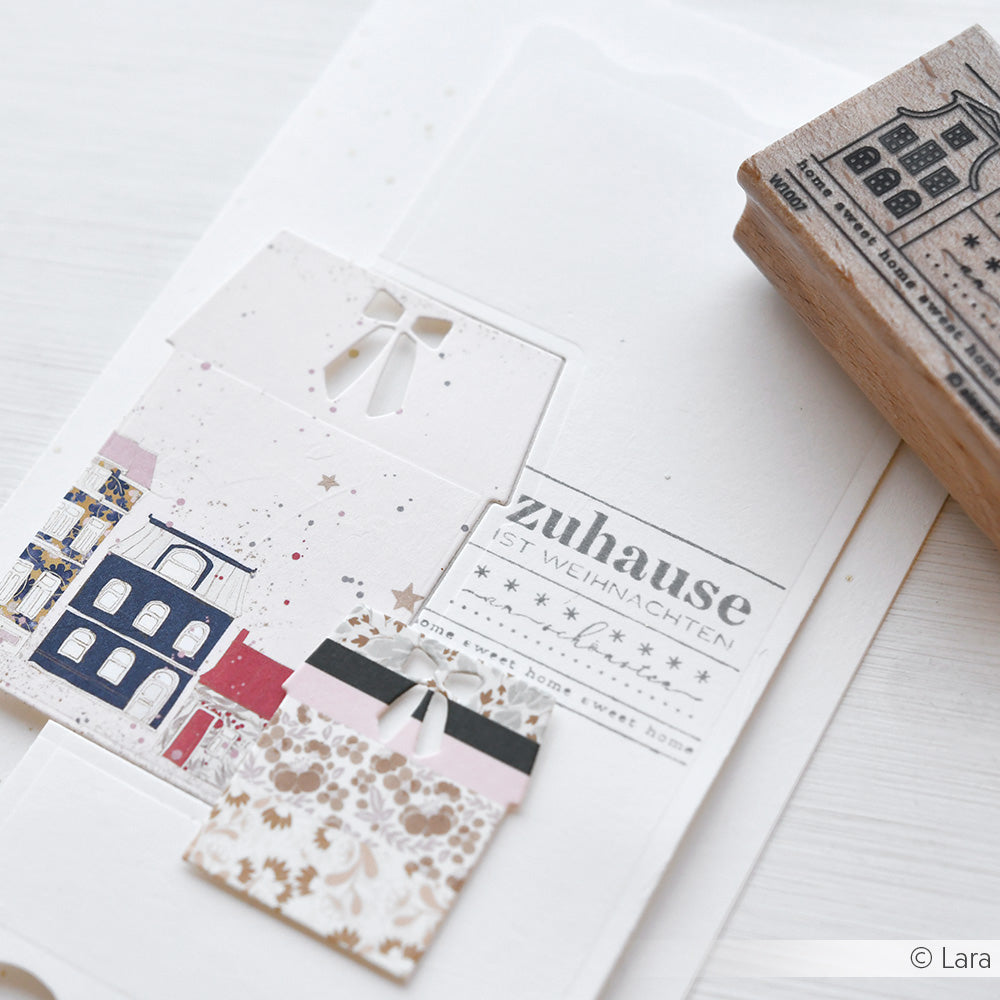 Weihnachtliche Geschenkkarte von Alexandra Renke mit Scherenschnitten, Holzstempeln und dem Spruch "Zuhause ist Weihnachten".