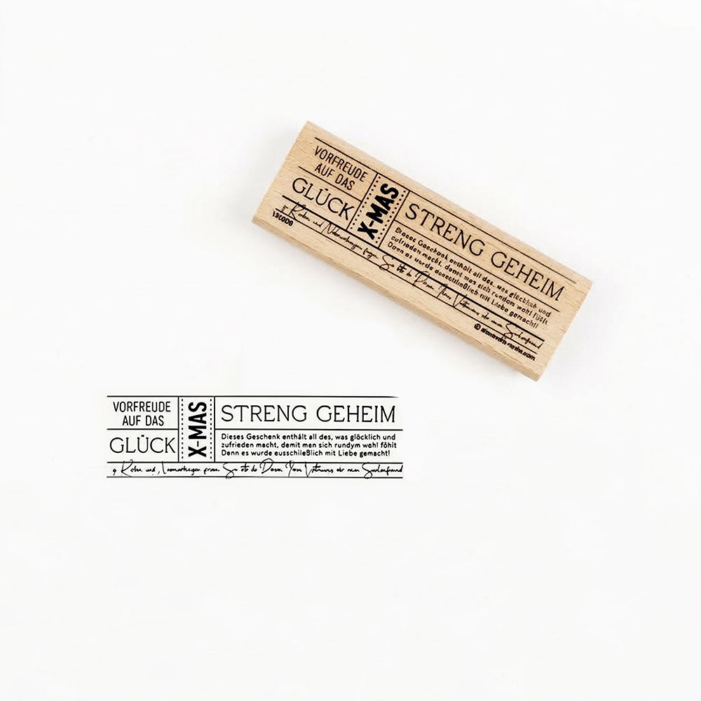 Holzstempel mit der Aufschrift Vorfreude auf das Glück X-MAS und schwarzem Stempelabdruck.