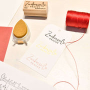 Geschenkanhänger mit detaillierten Motiven und süßer Fracht in verschiedenen Farben, Alexandra Renke Holzstempel, goldenes Stempelkissen und roter Faden auf einem Tisch - aus hochwertigen Materialien.