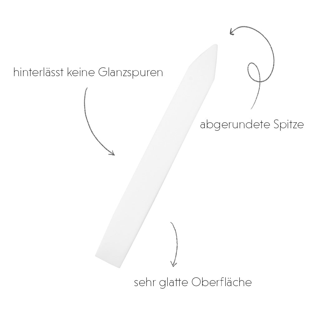 Der weiße Falzbein-Knochenfalter von Alexandra Renke hat eine spitze Spitze, eine glatte Oberfläche und einen deutschen Text, der seine Buchbinden-Qualitäten beschreibt.