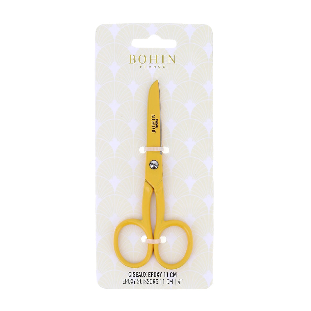Gelbe Epoxid-Schere von BOHIN France in der Verpackung, mit der Angabe „11 cm (4 Zoll)“ versehen und vor einem gemusterten Karton präsentiert. Die hochwertige Epoxidbeschichtung von BOHIN France gewährleistet lange Haltbarkeit und außergewöhnliche Schnittpräzision für alle Ihre Bastelprojekte.