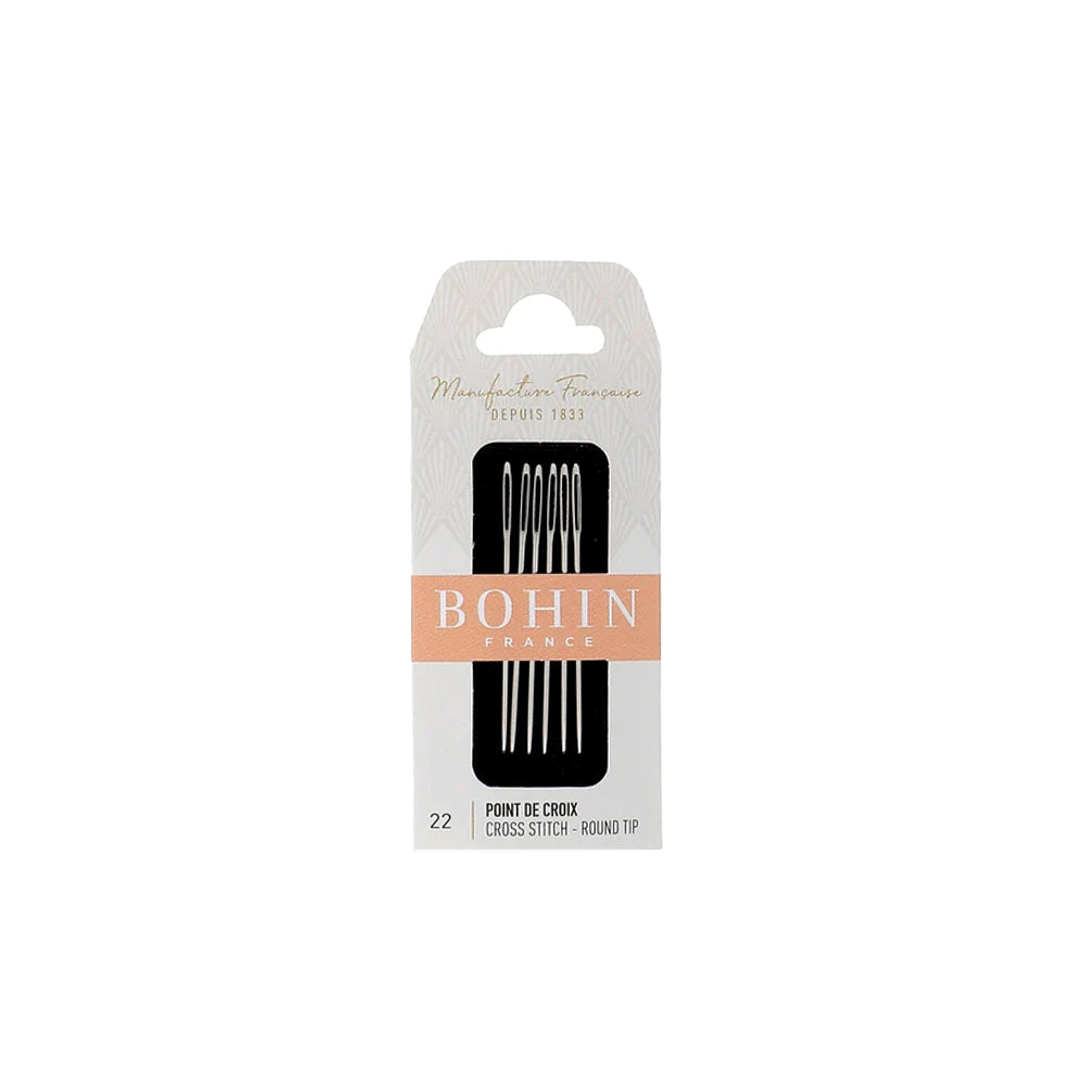 Eine Packung Kreuzstichnadeln der Größe 22 von BOHIN France mit abgerundeter Spitze, präsentiert in einer stilvollen Verpackung in Weiß und Pfirsichfarben.