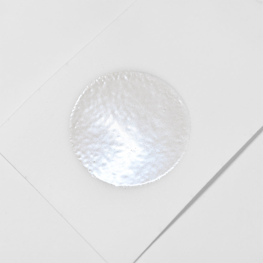 Ein runder, strukturierter weißer Aufkleber auf weißem Hintergrund, veredelt mit WOW Embossing Powder für einen eleganten Look.